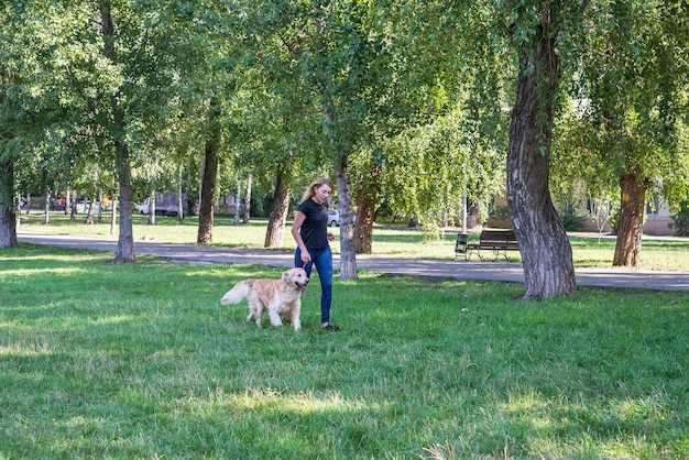 Jeune femme avec son chien retriever à l'extérieur.