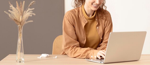 Jeune femme à son espace de travail à l'aide d'un ordinateur portable