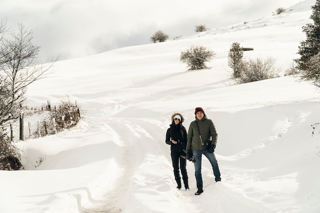 Jeune femme et son père ayant une promenade dans les montagnes enneigées du nord de l'Espagne