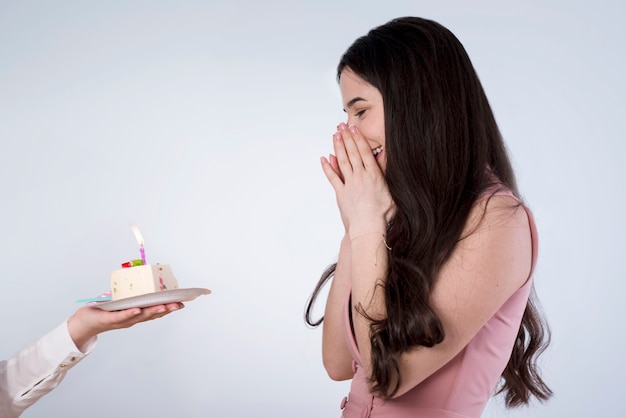 Photo jeune femme soufflant une bougie d'anniversaire