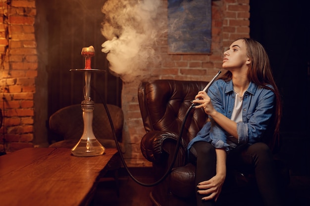 Jeune Femme Souffle De La Fumée Dans Un Bar à Narguilé, Se Détendre