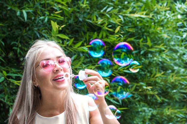 Jeune femme souffle souffleur de bulles dans la rue