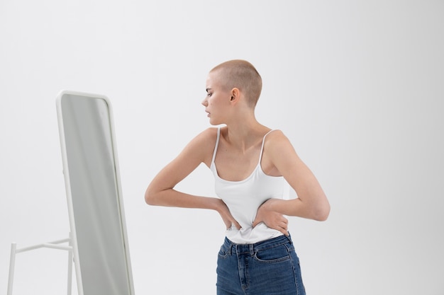 Photo jeune femme souffrant d'un trouble de l'alimentation se vérifiant dans le miroir