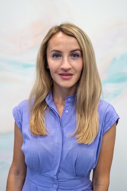 Jeune femme souriant gentiment à la caméra et posant en studio