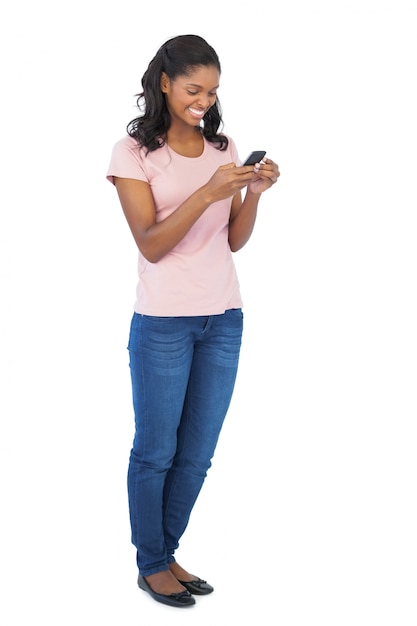 Jeune femme souriante et à l&#39;aide de téléphone portable