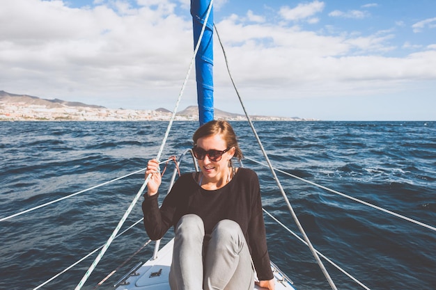 Photo une jeune femme souriante assise dans un bateau en mer.