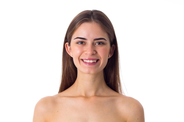 Jeune femme souriante aux longs cheveux bruns sur fond blanc en studio