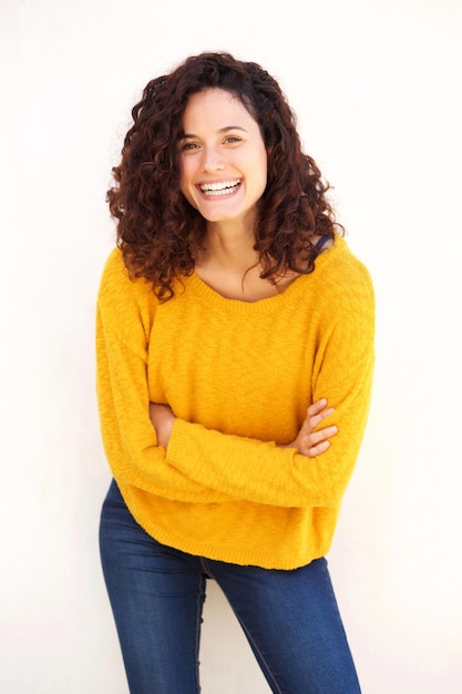 Une jeune femme souriante avec les bras croisés sur un fond blanc isolé