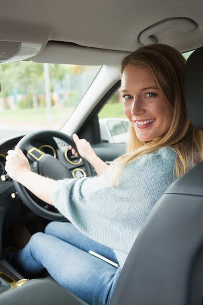 Jeune femme souriante en conduisant
