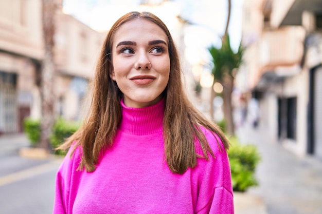 Jeune femme souriante confiante regardant sur le côté dans la rue