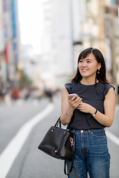 Une jeune femme souriante debout dans la rue de la ville