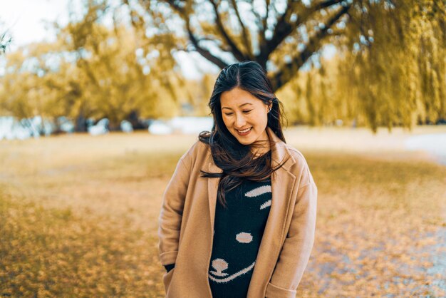 Jeune femme souriante debout sur la terre pendant l'automne