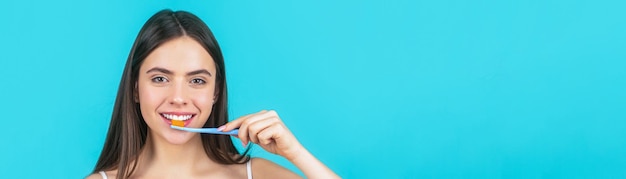 Jeune femme souriante avec des dents saines tenant une brosse à dents Jeune belle fille