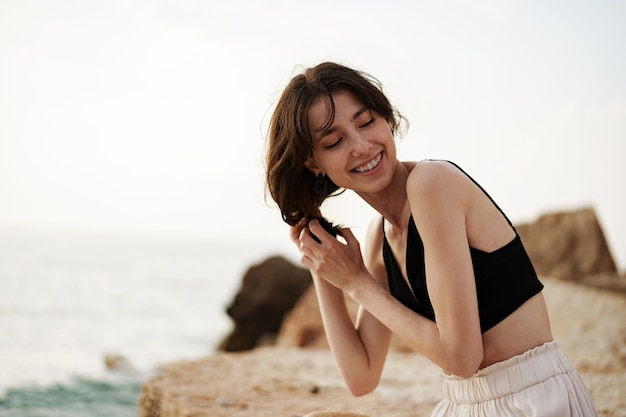 Jeune femme souriante à l'extérieur portrait à la plage