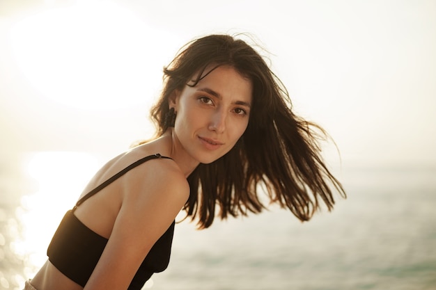 Jeune femme souriante à l'extérieur portrait à la plage