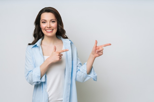 Jeune femme souriante et faisant des gestes pour copier l'espace