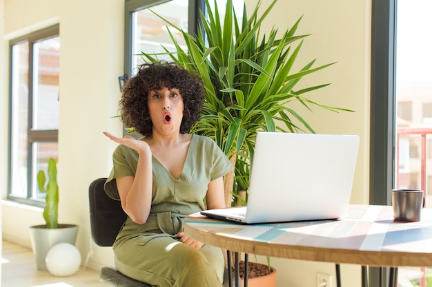 Jeune femme souriante fièrement et avec confiance en faisant le numéro un pose triomphalement, se sentant comme un leader