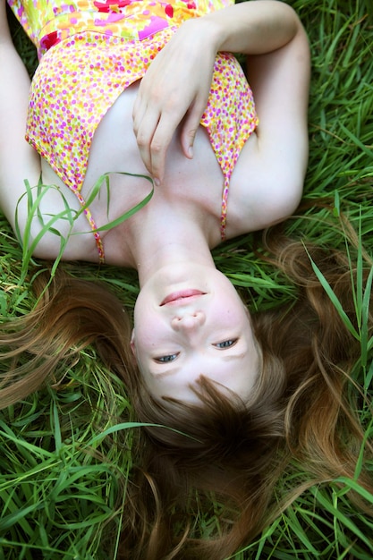 Jeune femme souriante sur l'herbe