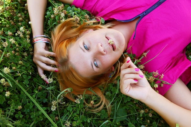 Jeune femme souriante sur l'herbe