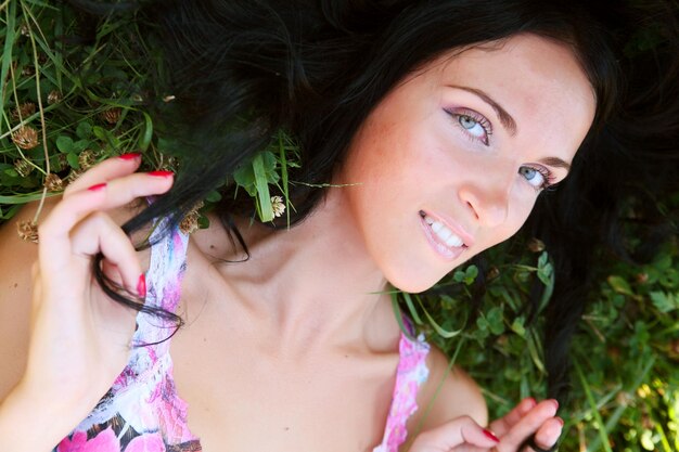 Jeune femme souriante sur l'herbe