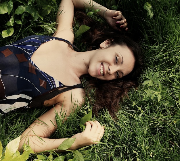 Jeune femme souriante sur l'herbe
