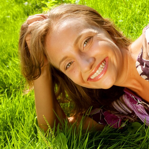 Jeune femme souriante sur l'herbe