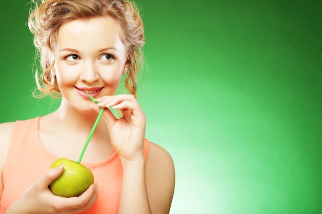 Jeune femme souriante heureuse avec cocktail pomme et pailles