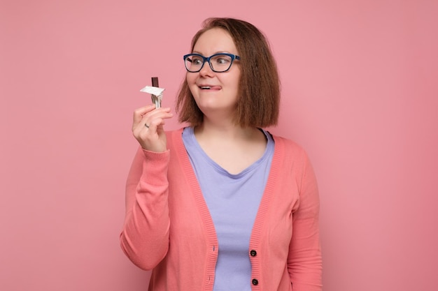 Jeune femme souriante heureuse voulant manger du chocolat