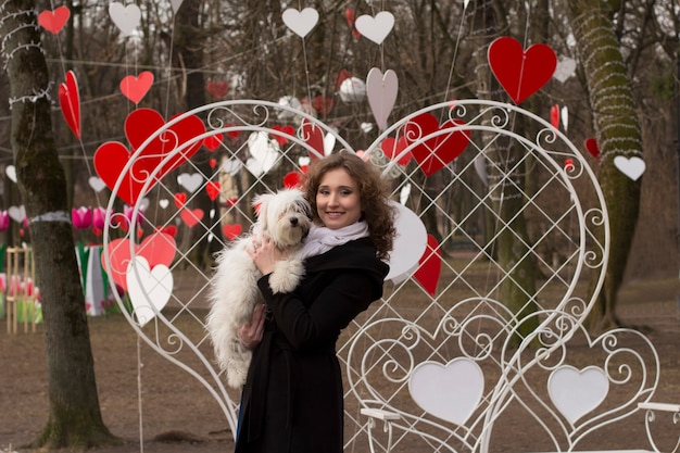 Jeune femme souriante jouant avec son chien dans la rue