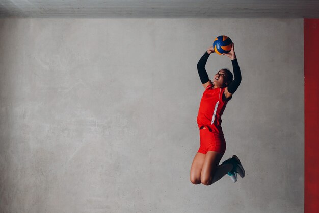 Jeune femme souriante joueur de volley-ball avec ballon.