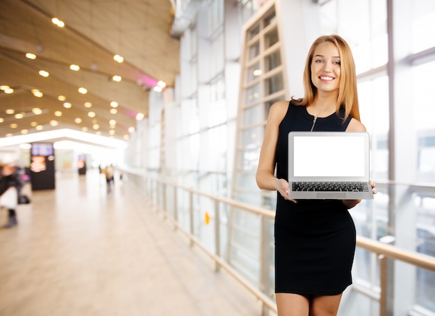 Jeune femme souriante joyeuse détient un ordinateur portable