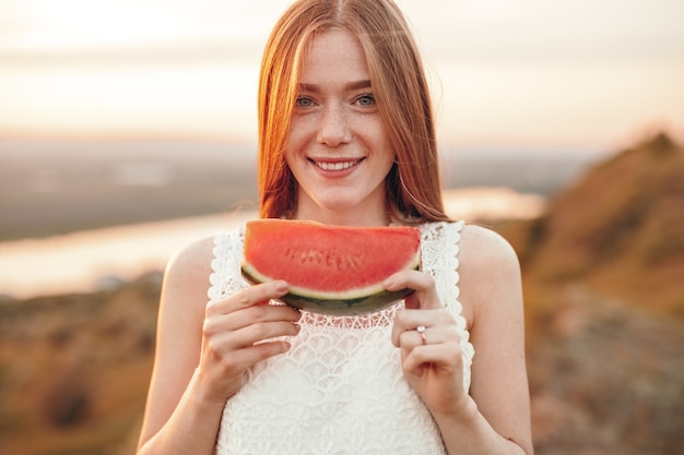 Jeune femme souriante avec morceau de pastèque mûre