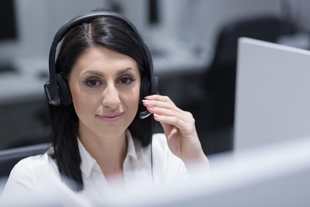 jeune femme souriante opératrice de centre d'appels faisant son travail avec un casque