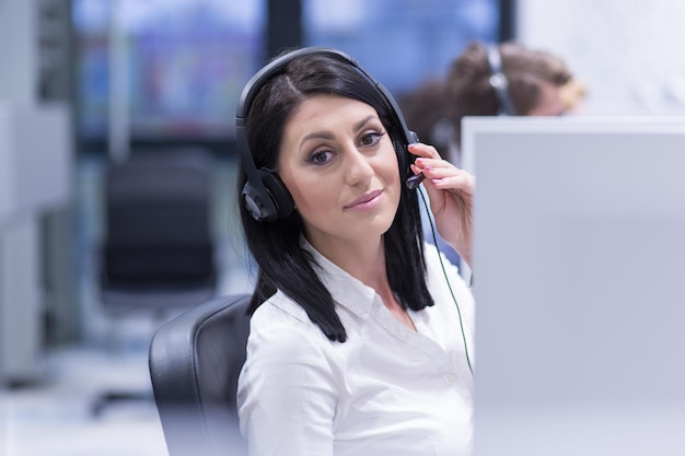 jeune femme souriante opératrice de centre d'appels faisant son travail avec un casque