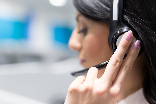 jeune femme souriante opératrice de centre d'appels faisant son travail avec un casque