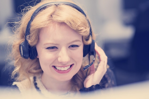 jeune femme souriante opératrice de centre d'appels faisant son travail avec un casque