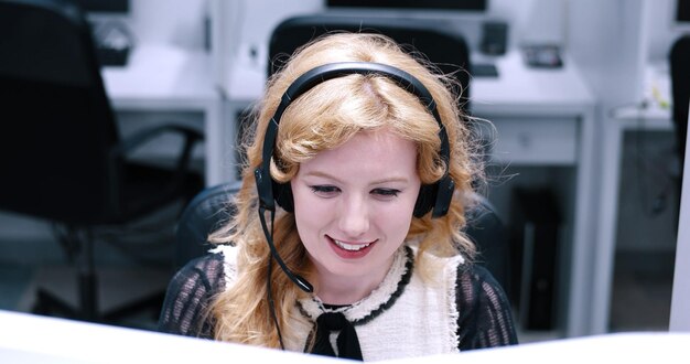 jeune femme souriante opératrice de centre d'appels faisant son travail avec un casque