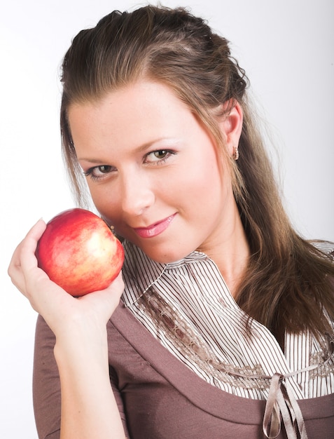 Jeune femme souriante avec pomme rouge.