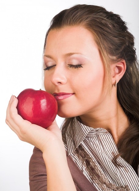 Jeune femme souriante avec pomme rouge.