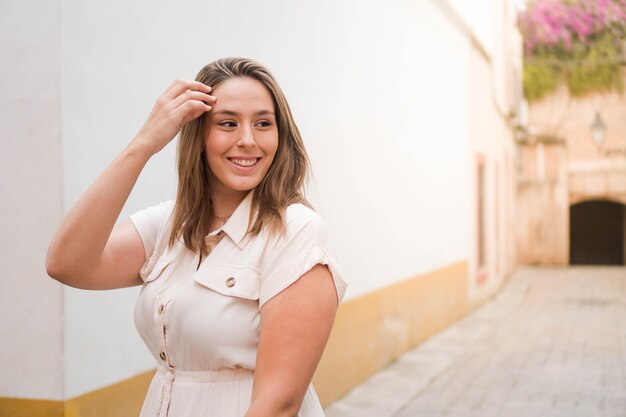 Jeune femme souriante profitant de l'été Fille brune dans une combinaison beige dans la rue