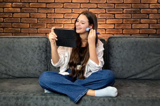 Une jeune femme souriante qui se maquille