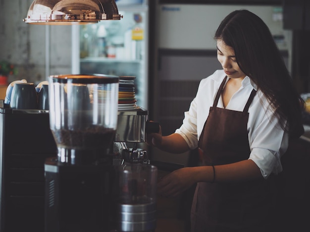 Une jeune femme souriante qui travaille dans un café.