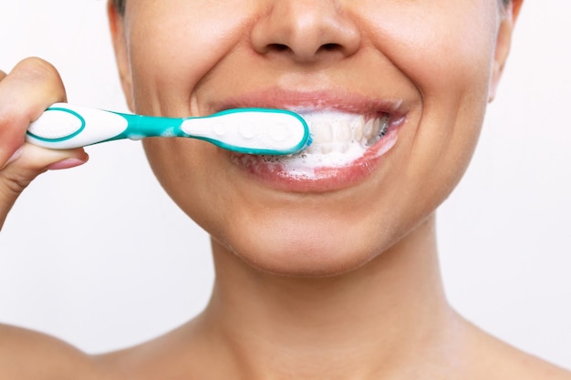 Jeune femme souriante se brossant les dents avec une brosse à dents Routine du matin et du soir Gros plan