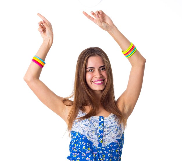 Jeune femme souriante en T-shirt bleu avec des bracelets multicolores tenant les mains sur fond blanc en studio