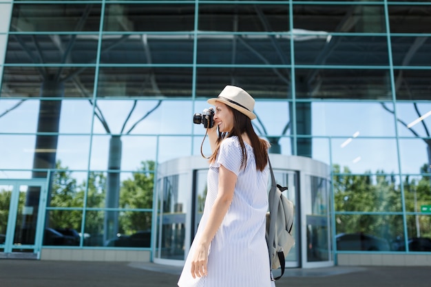 Jeune femme souriante touristique voyageur prenant des photos sur un appareil photo vintage rétro sur le passage pour piétons à l'aéroport international