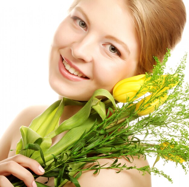 Jeune femme souriante avec des tulipes jaunes