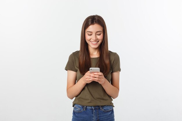 Une jeune femme souriante utilisant un smartphone sur un fond blanc