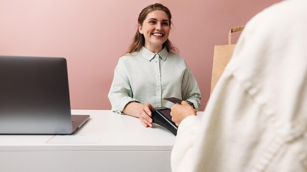 Photo une jeune femme souriante utilisant le téléphone alors qu'elle est assise sur la table