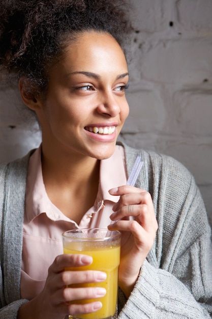 Jeune femme souriante avec un verre de jus d&#39;orange