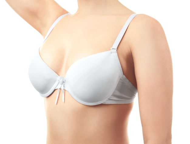 Jeune femme en soutien-gorge sur fond blanc